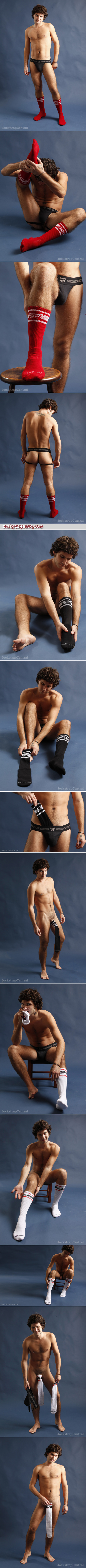 Cute young furry guy in a black jockstrap trying on socks designed with male foot fetishists in mind.